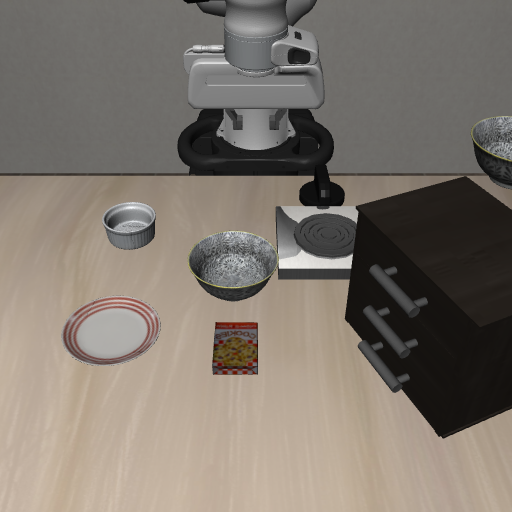 two identical black bowls, one on the stove and one on the table